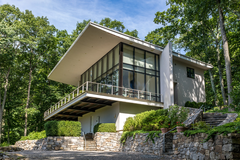 White contemporary two floor detached house in New York with a flat roof.