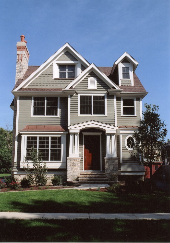 Cette image montre une petite façade de maison verte rustique en bois à deux étages et plus.