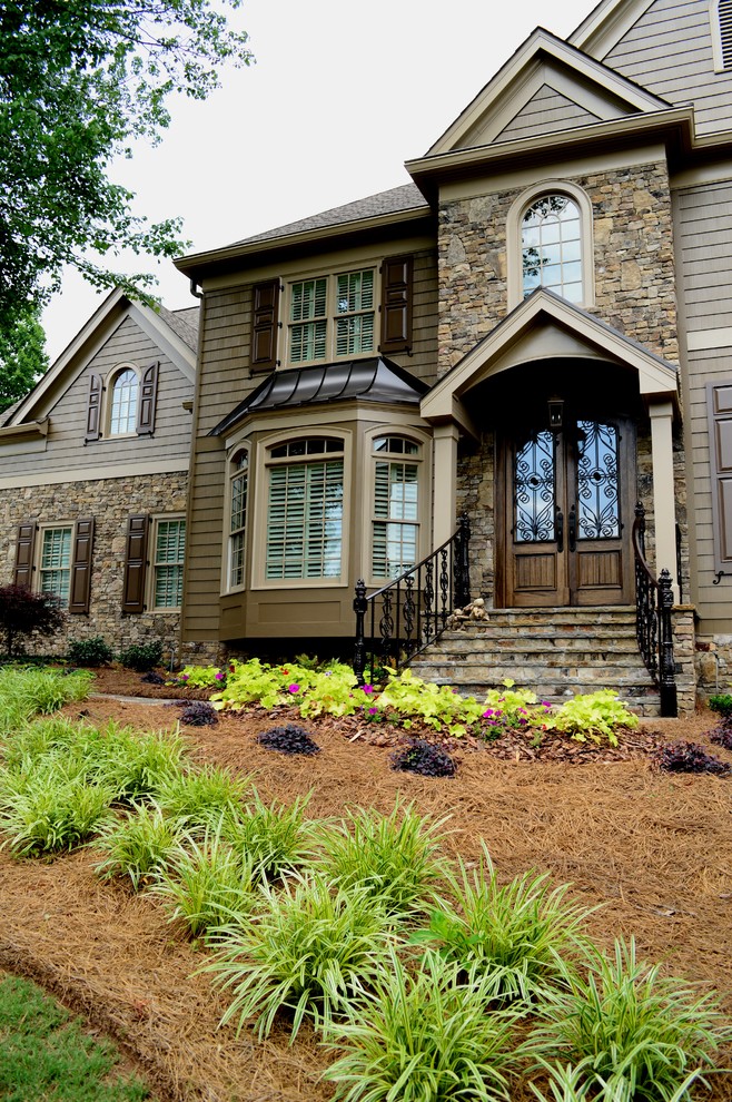 This is an example of a large and brown classic house exterior in Atlanta with three floors, wood cladding and a hip roof.