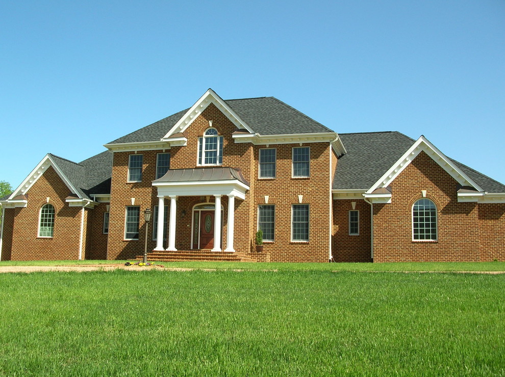 Пример оригинального дизайна: двухэтажный, кирпичный, красный дом среднего размера в классическом стиле с двускатной крышей