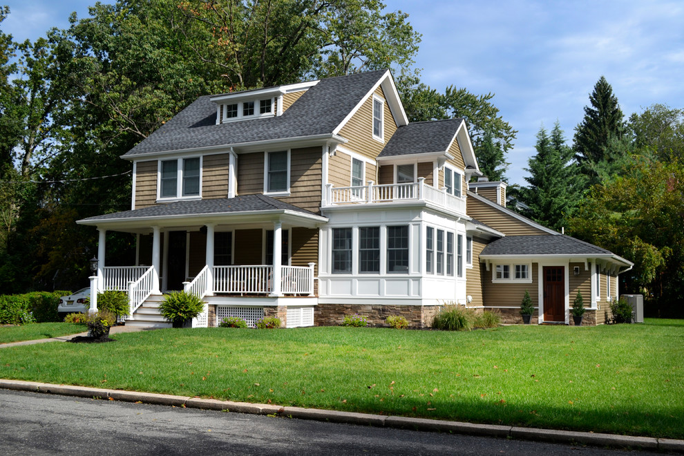 Imagen de fachada de casa beige clásica de tamaño medio de dos plantas con tejado a dos aguas, revestimiento de vinilo y tejado de teja de madera