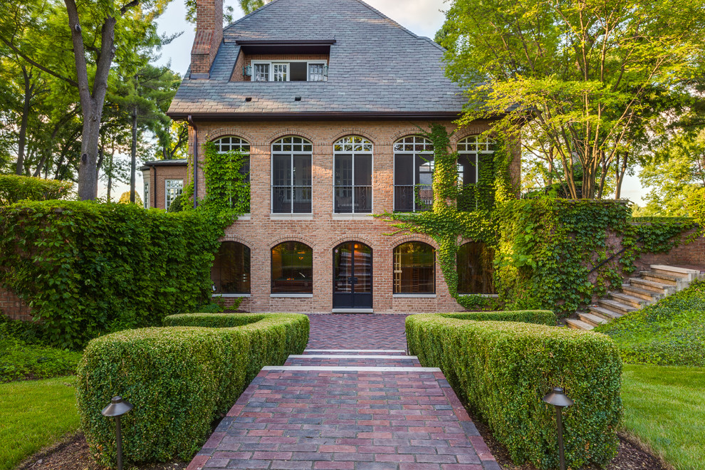 Example of a classic red brick exterior home design in Chicago with a hip roof