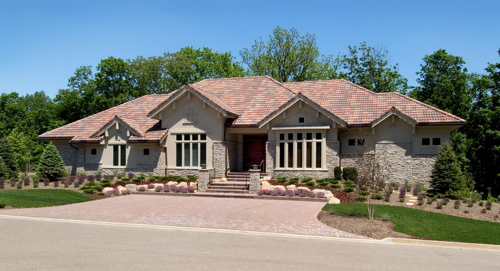 Esempio della facciata di una casa beige american style a un piano di medie dimensioni con rivestimento in pietra e tetto a capanna
