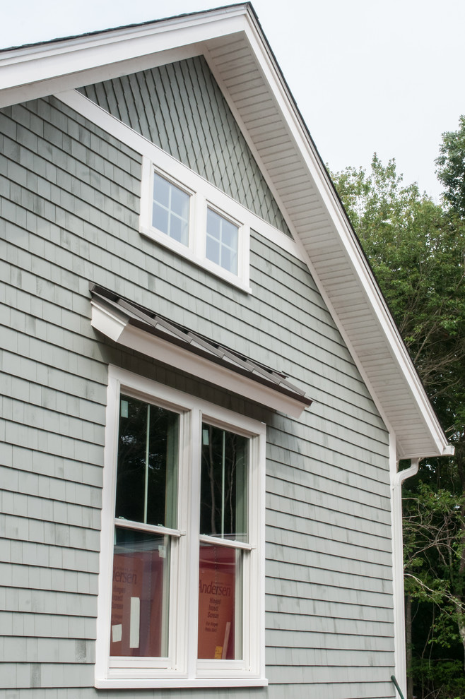 Modelo de fachada de casa azul costera grande de una planta con revestimiento de madera, tejado a dos aguas y tejado de teja de madera