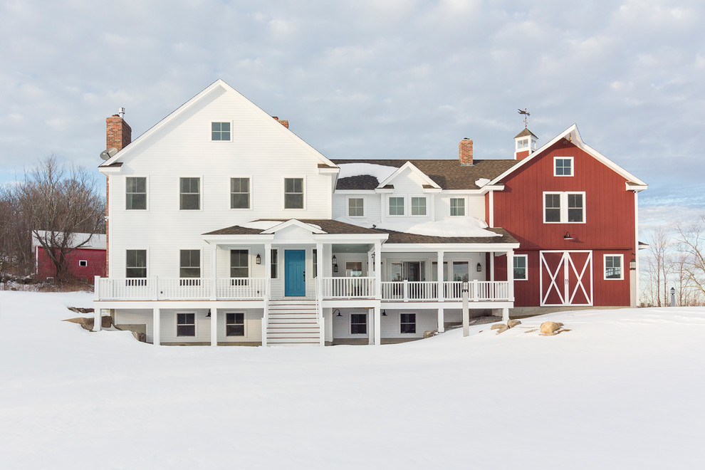 Immagine della villa bianca country a due piani con tetto a capanna