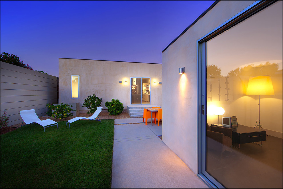 Réalisation d'une façade de maison beige design en stuc de taille moyenne et de plain-pied avec un toit plat.