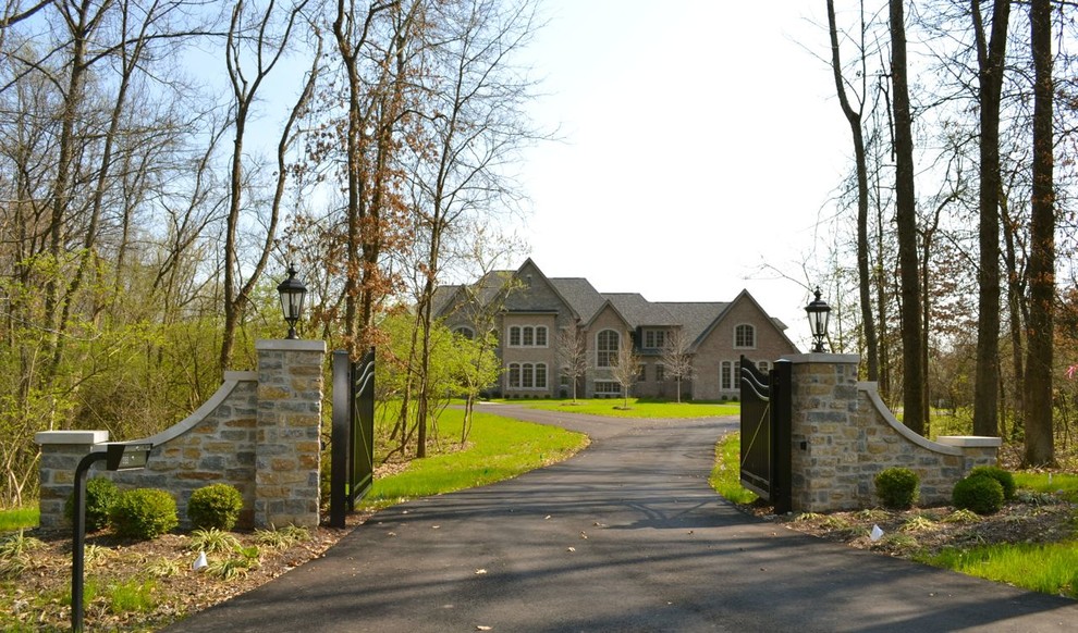 Huge elegant beige two-story brick exterior home photo in Cincinnati
