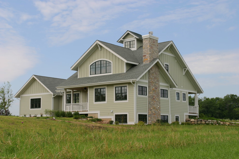 Cette photo montre une grande façade de maison verte chic en bois à deux étages et plus avec un toit à deux pans et un toit en shingle.