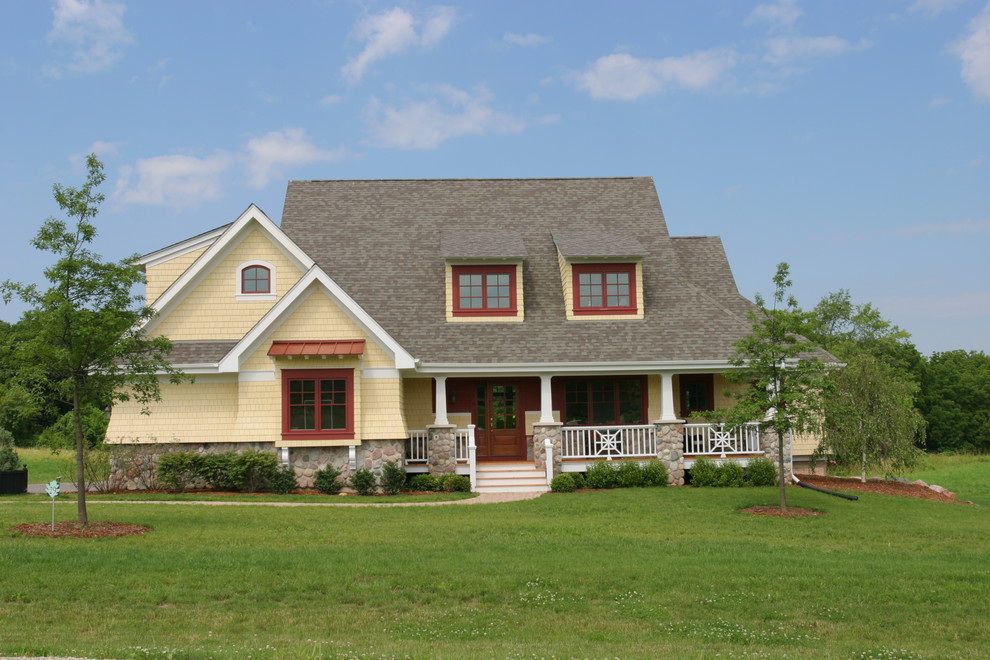 Exemple d'une façade de maison jaune chic de taille moyenne et à un étage avec un revêtement mixte, un toit à deux pans et un toit en shingle.