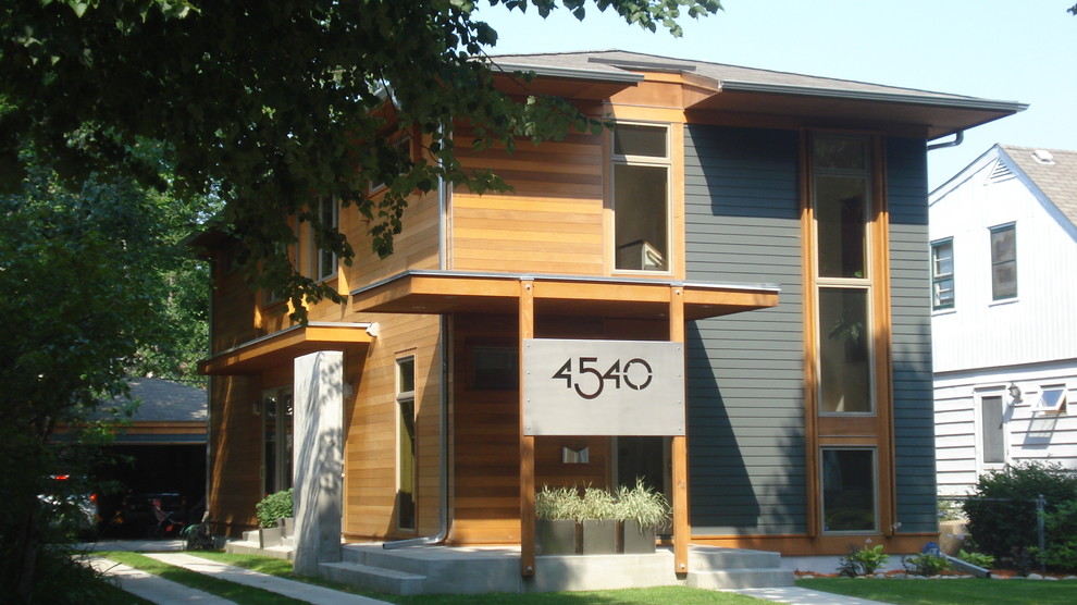 Exemple d'une façade de maison grise moderne en bois de taille moyenne et à un étage avec un toit à quatre pans et un toit en shingle.