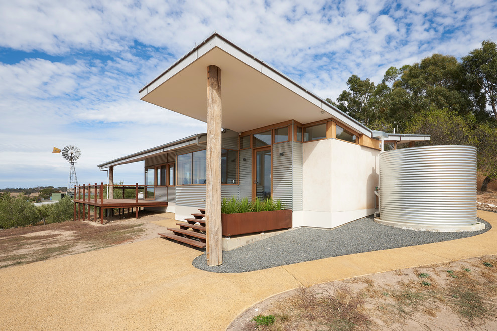Idee per la villa beige contemporanea a un piano di medie dimensioni con rivestimento in adobe, tetto a capanna e copertura in metallo o lamiera