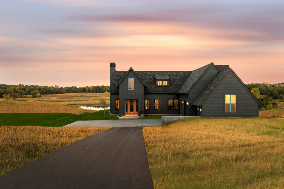 Großes Landhaus Haus mit schwarzer Fassadenfarbe, Satteldach, Schindeldach und schwarzem Dach in Minneapolis