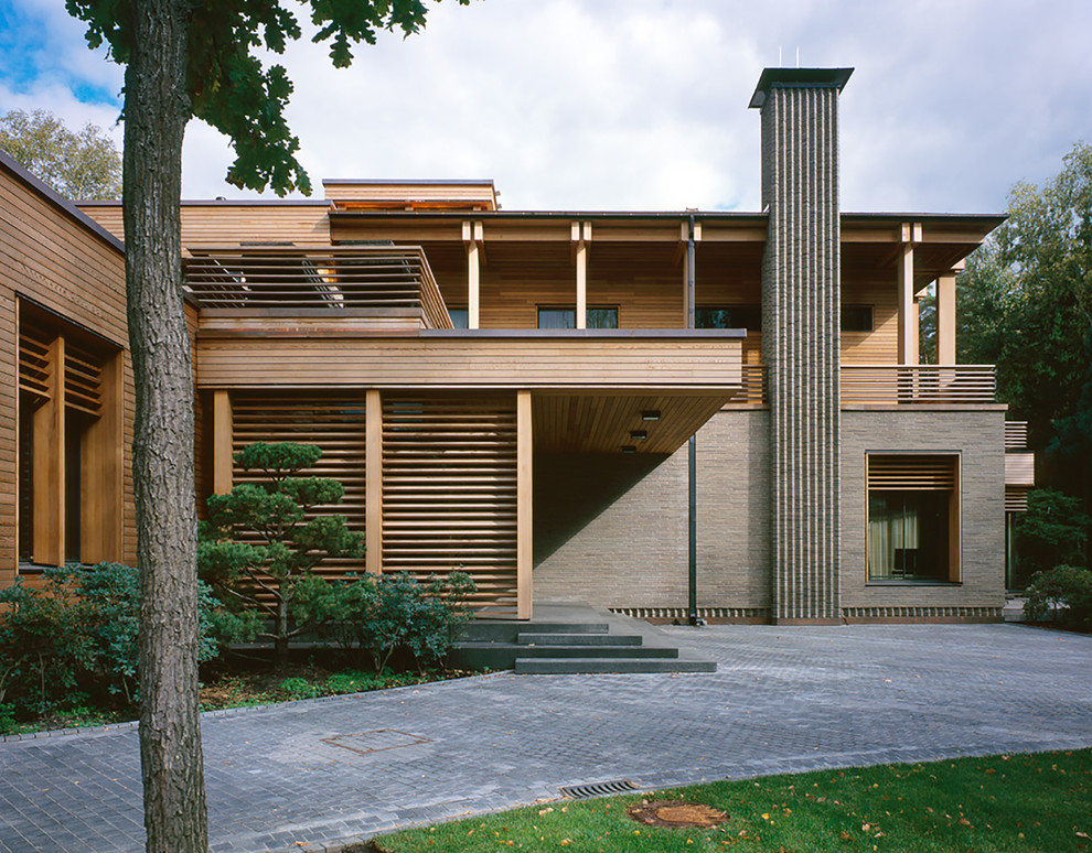 Idée de décoration pour une grande façade de maison multicolore minimaliste à un étage avec un revêtement mixte et un toit plat.