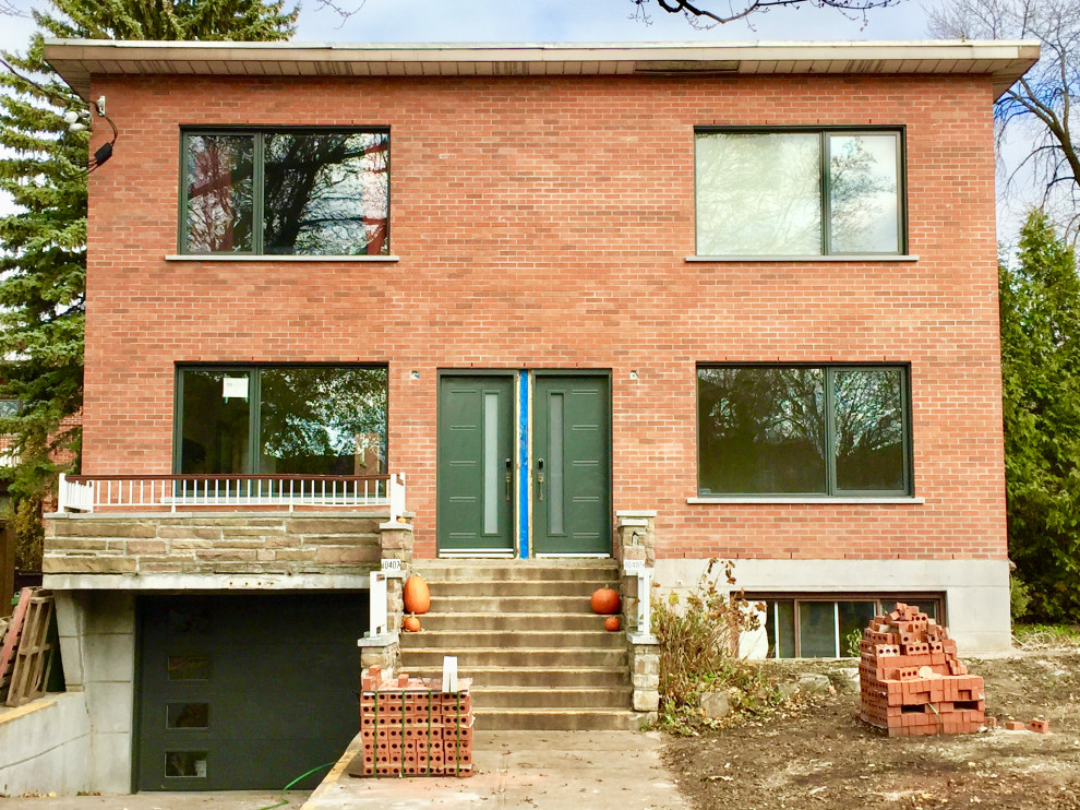 Große, Zweistöckige Moderne Doppelhaushälfte mit Backsteinfassade, roter Fassadenfarbe, Flachdach und Blechdach
