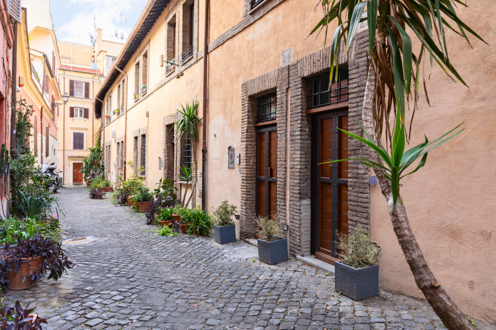 Kleines, Zweistöckiges Uriges Reihenhaus mit Putzfassade, beiger Fassadenfarbe, Mansardendach und Ziegeldach in Rom