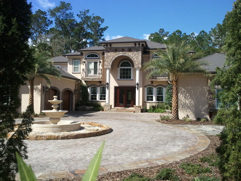 Large tuscan beige two-story stucco house exterior photo in Jacksonville with a hip roof and a shingle roof