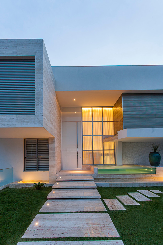Großes, Einstöckiges Modernes Haus mit Steinfassade, weißer Fassadenfarbe und Flachdach in Sonstige