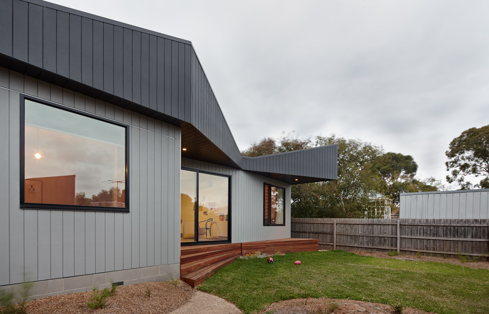 Cette photo montre une façade de maison grise tendance en bois de plain-pied.