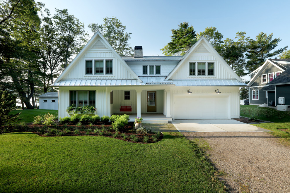 Modelo de fachada de casa blanca tradicional de tamaño medio de dos plantas con tejado a dos aguas, revestimientos combinados y tejado de varios materiales
