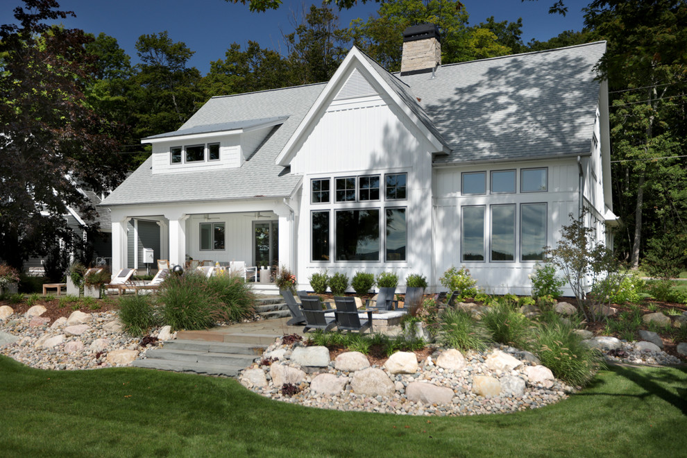 Ejemplo de fachada de casa blanca clásica de tamaño medio de dos plantas con tejado a dos aguas, tejado de varios materiales y revestimientos combinados