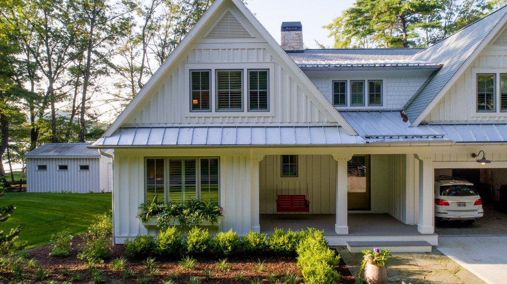 Ejemplo de fachada de casa blanca clásica de tamaño medio de dos plantas con tejado a dos aguas, revestimientos combinados y tejado de varios materiales