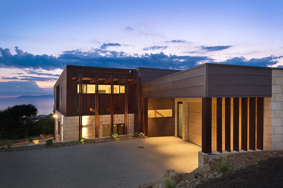 Стильный дизайн: большой, двухэтажный, коричневый частный загородный дом в современном стиле с облицовкой из камня и плоской крышей - последний тренд