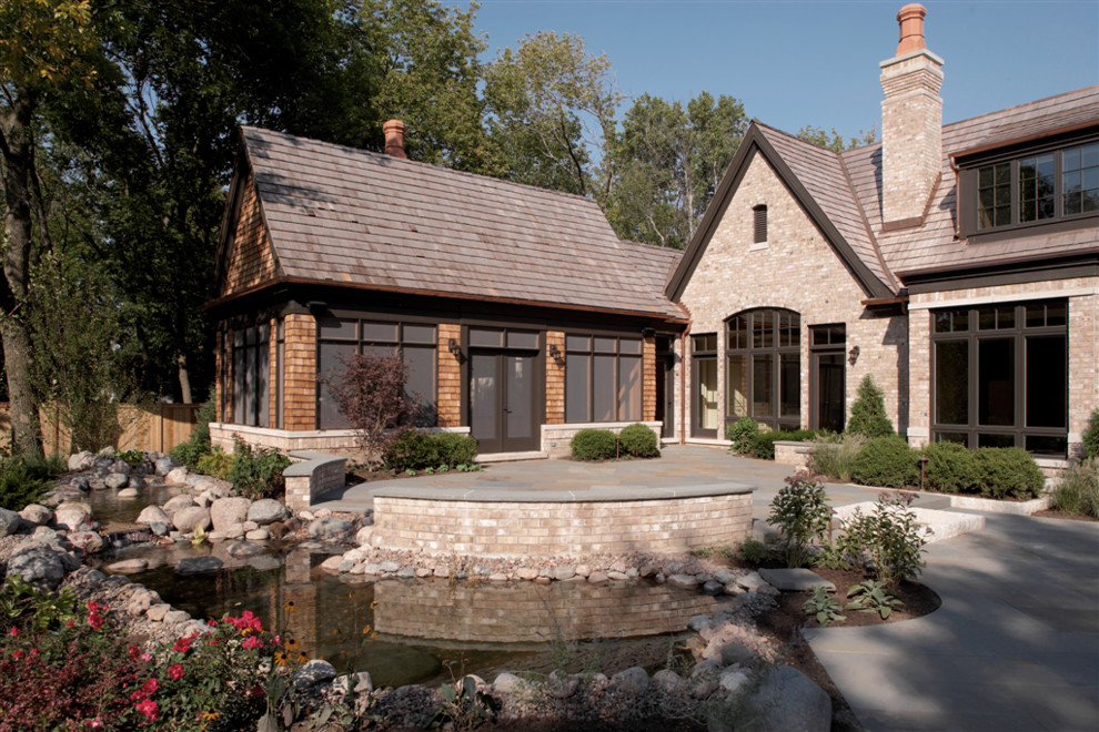 Large traditional beige two-story brick gable roof idea in Chicago