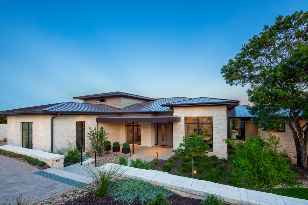 Inspiration for a contemporary house exterior remodel in Austin with a hip roof and a metal roof