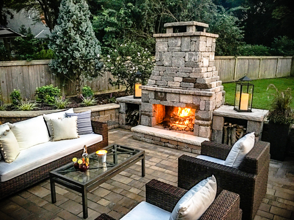 Inspiration for a large modern backyard concrete paver patio remodel in Kansas City with a fireplace