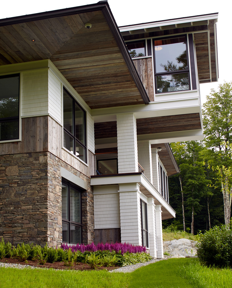 Cette photo montre une grande façade de maison blanche tendance en bois à deux étages et plus avec un toit à deux pans.
