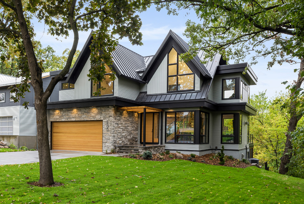 Inspiration pour une grande façade de maison grise design à un étage avec un revêtement mixte, un toit à deux pans et un toit en métal.