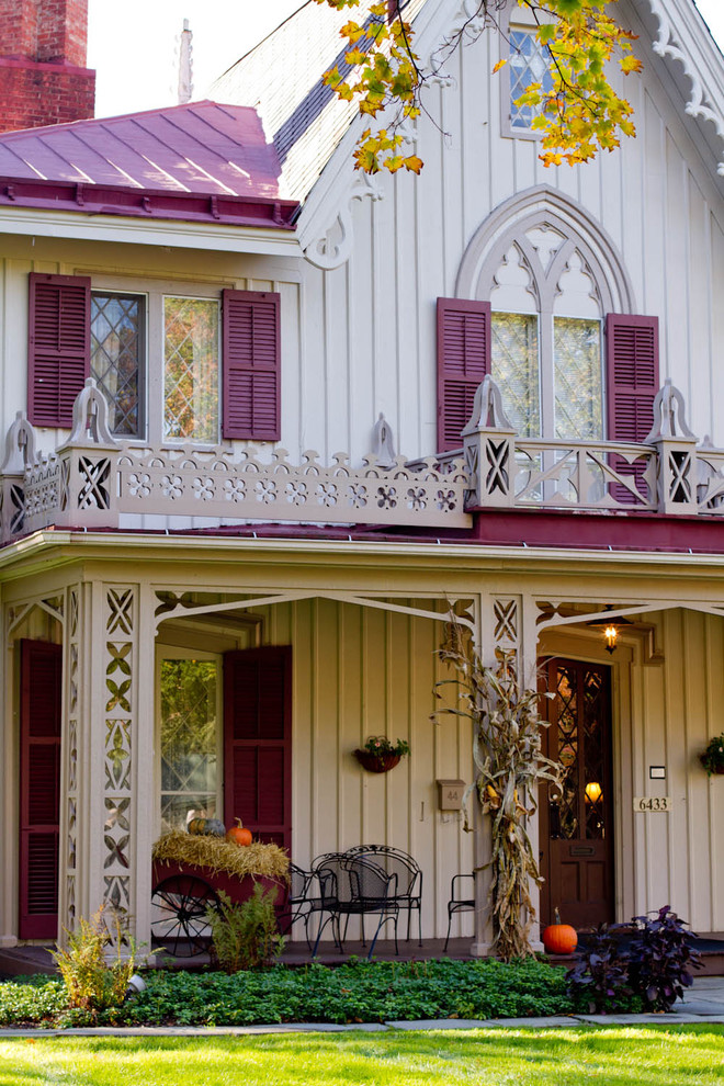 Inspiration for a classic two floor house exterior in New York with wood cladding and a red roof.