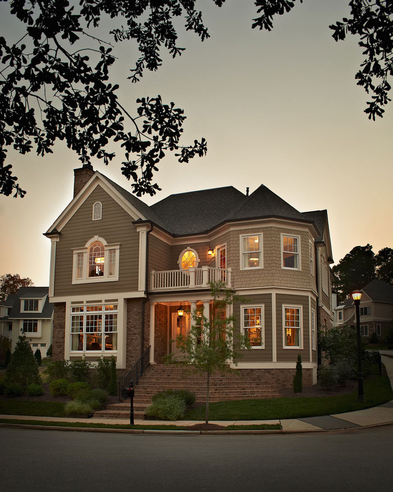 Aménagement d'une grande façade de maison beige classique à un étage avec un revêtement en vinyle, un toit à croupette et un toit en shingle.
