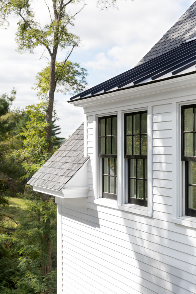 Ejemplo de fachada de casa blanca de estilo de casa de campo grande de dos plantas con revestimiento de madera y tejado de teja de madera