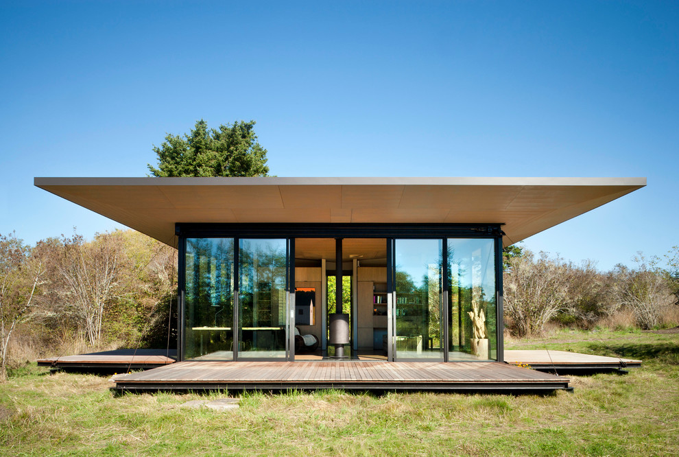 Réalisation d'une petite façade de maison minimaliste en bois de plain-pied avec un toit plat.