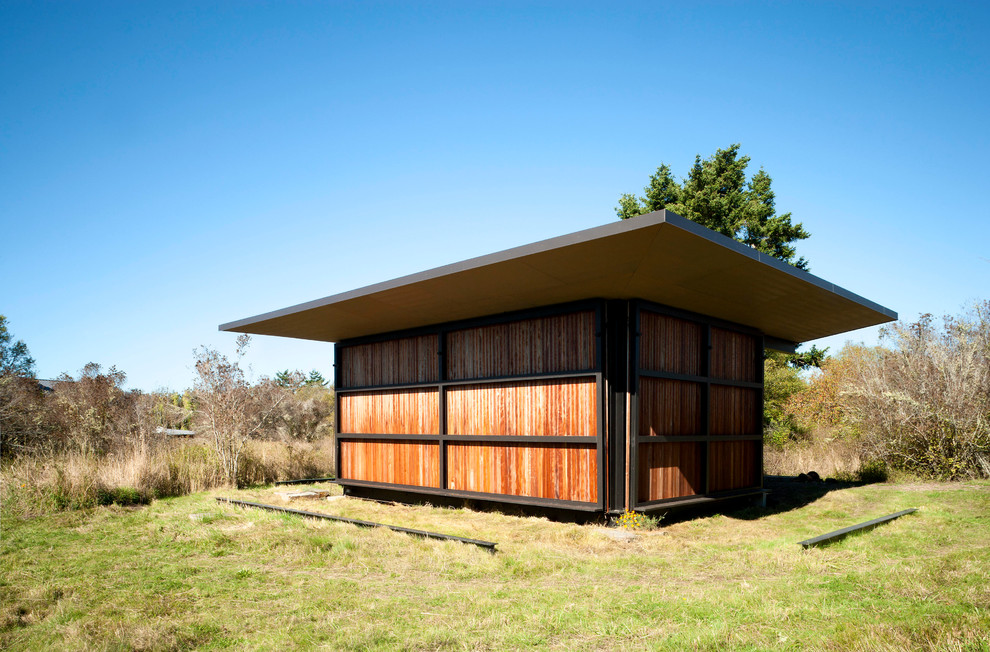 Пример оригинального дизайна: маленький, одноэтажный, деревянный, коричневый дом в стиле модернизм с плоской крышей для на участке и в саду