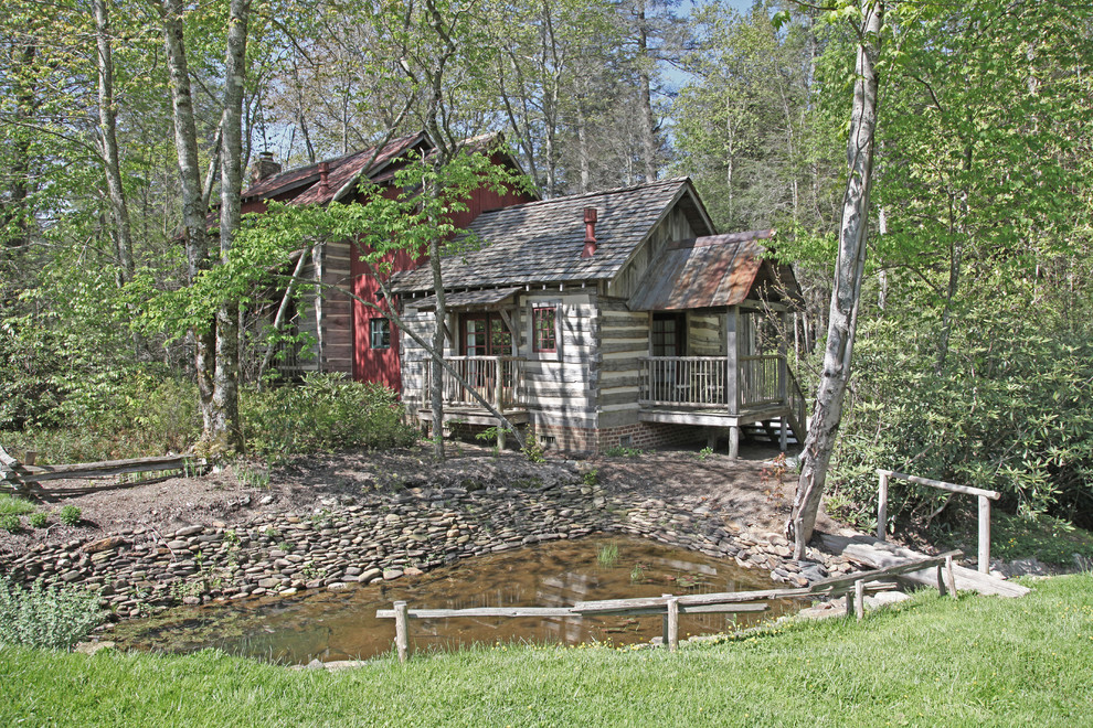 Photo of a medium sized and gey rustic two floor house exterior in Other with wood cladding.