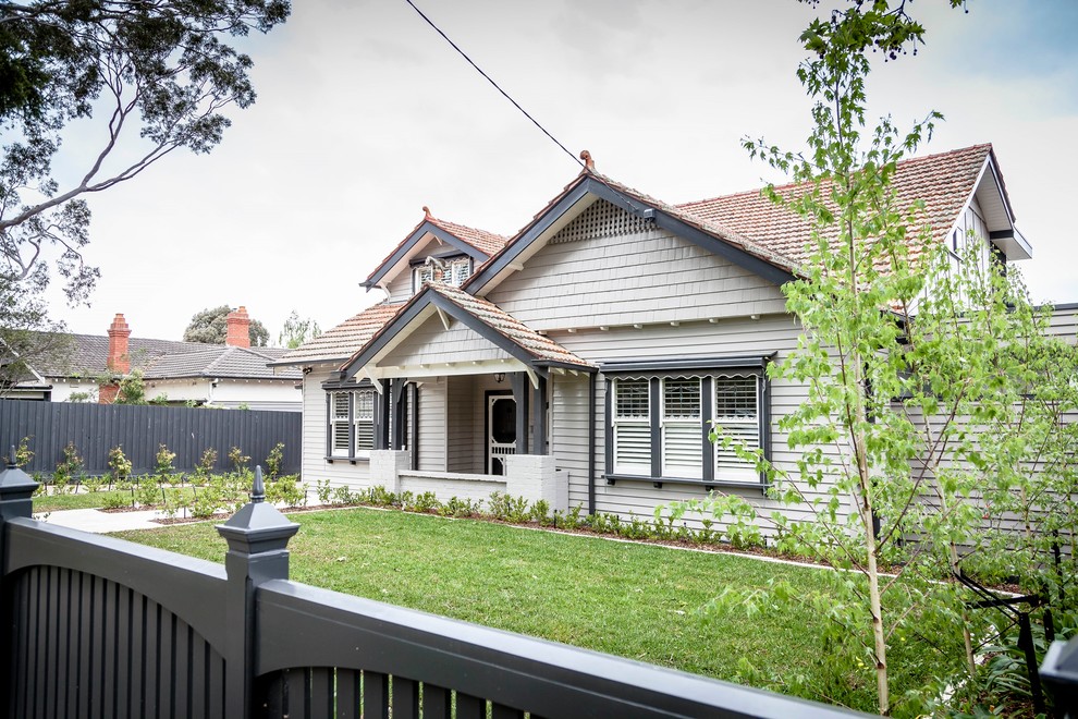 Large and gey traditional two floor house exterior in Melbourne with mixed cladding and a pitched roof.