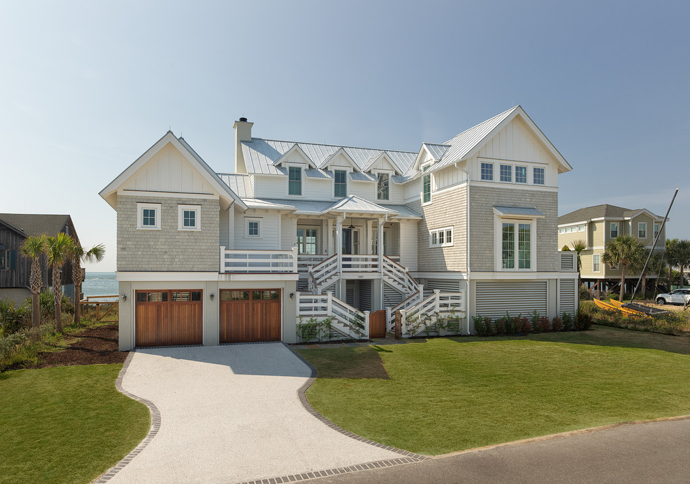 Idée de décoration pour une grande façade de maison beige marine à deux étages et plus avec un revêtement mixte, un toit à deux pans et un toit en métal.