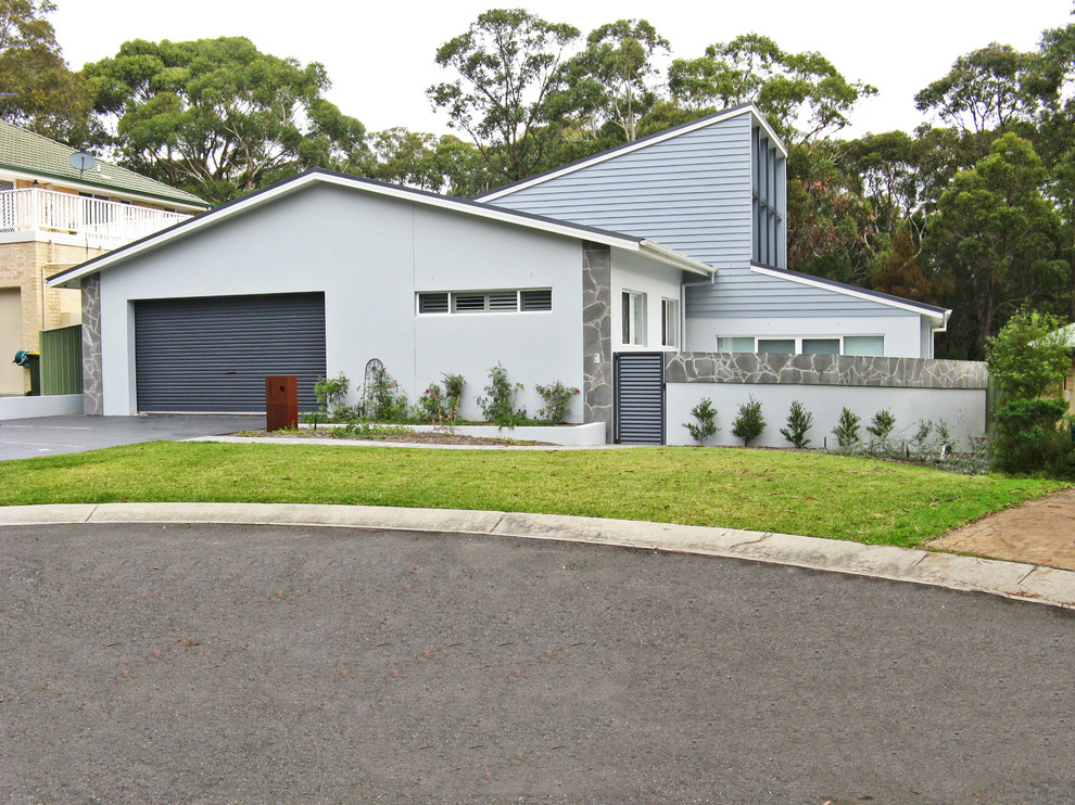Medium sized and blue contemporary two floor house exterior in Sydney with stone cladding.