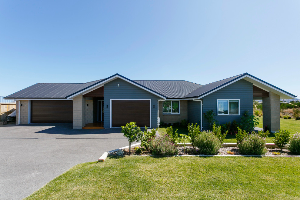 Cette photo montre une façade de maison multicolore tendance en brique de taille moyenne et de plain-pied avec un toit à deux pans et un toit en métal.