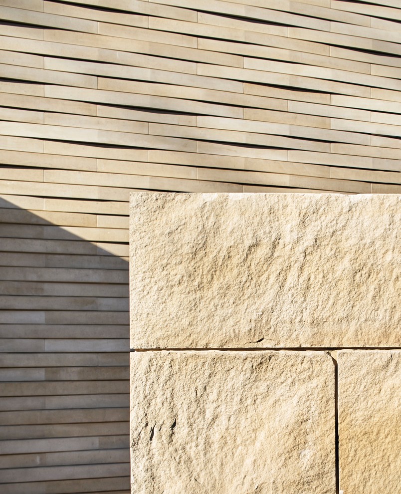 Immagine della villa beige contemporanea a due piani con rivestimento in pietra