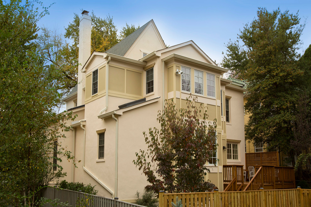 Cette image montre une façade de maison beige traditionnelle avec un revêtement mixte.