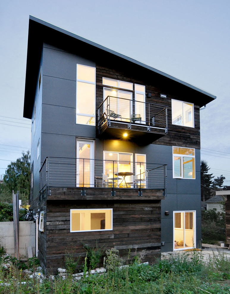 Inspiration pour une façade de maison design à deux étages et plus avec un revêtement mixte et un toit en appentis.