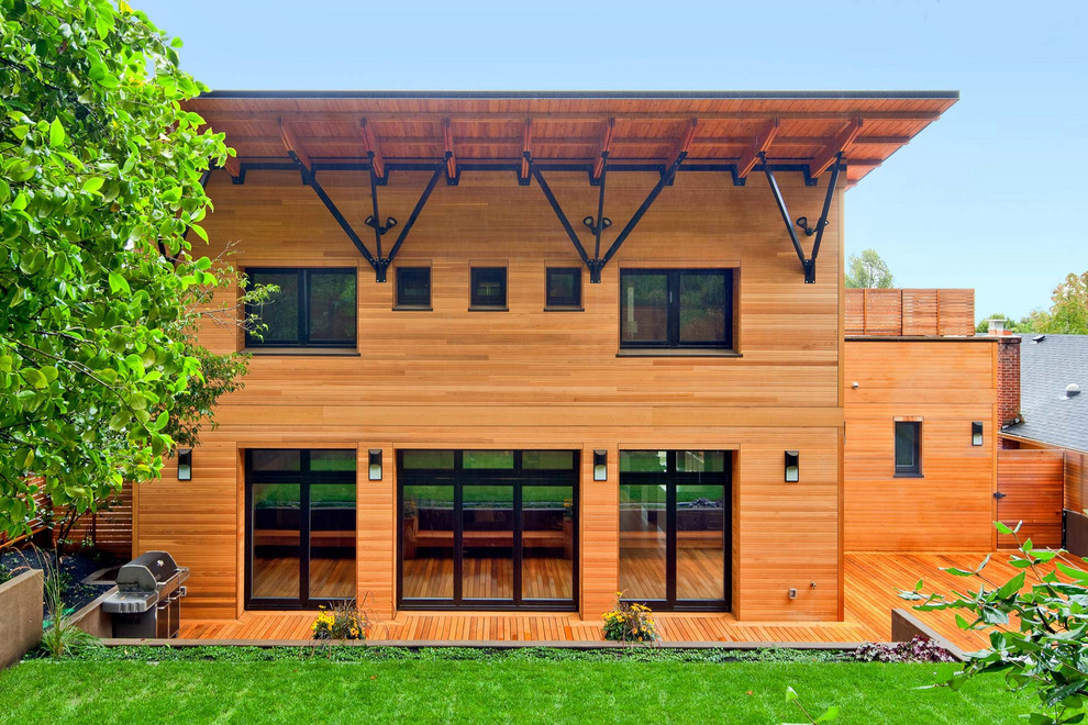 Ejemplo de fachada de casa beige de estilo americano grande de dos plantas con revestimiento de madera, tejado de un solo tendido y tejado de teja de madera