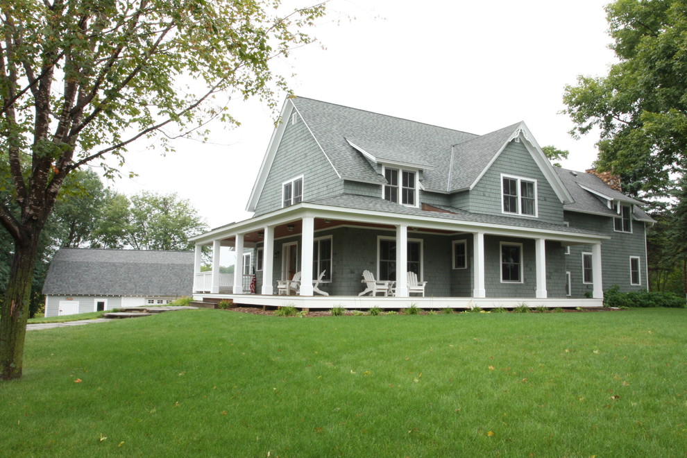 Ejemplo de fachada verde de estilo de casa de campo con revestimiento de madera y tejado a dos aguas