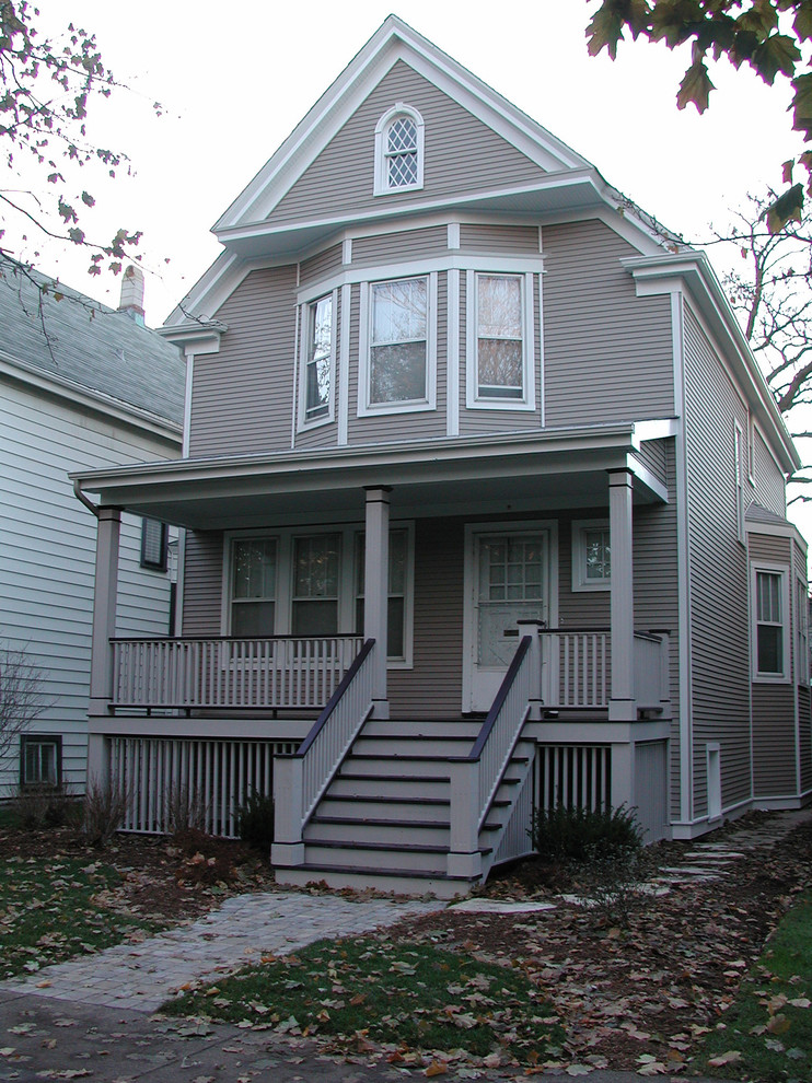 Mittelgroßes, Zweistöckiges Landhaus Haus mit Vinylfassade, beiger Fassadenfarbe und Satteldach in Chicago