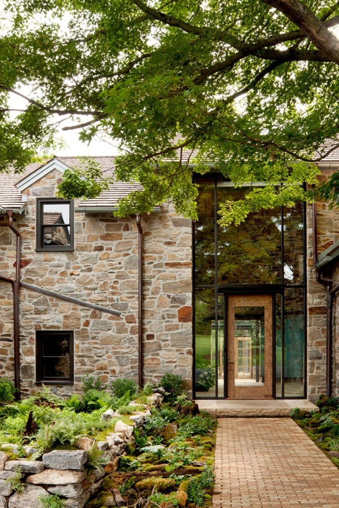 Foto de fachada beige de estilo de casa de campo grande de dos plantas con revestimiento de piedra y tejado a dos aguas