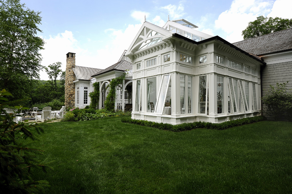 Cette image montre une grande façade de maison grise traditionnelle de plain-pied avec un revêtement mixte.