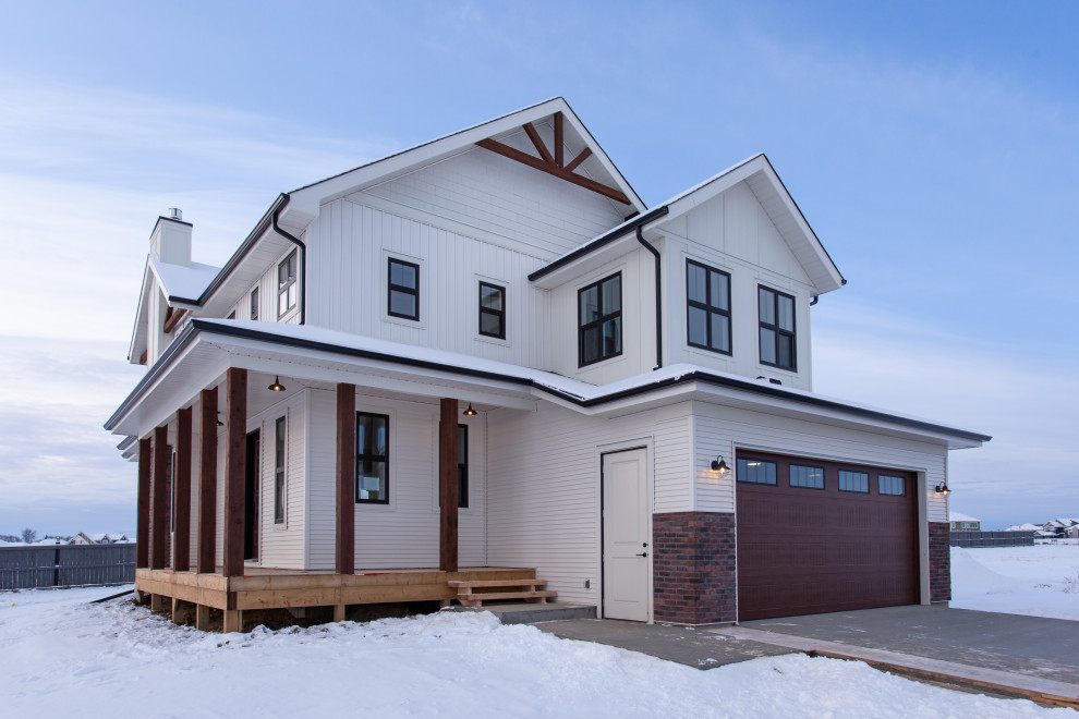Mittelgroßes, Zweistöckiges Landhaus Einfamilienhaus mit Vinylfassade, weißer Fassadenfarbe, Pultdach und Schindeldach in Edmonton